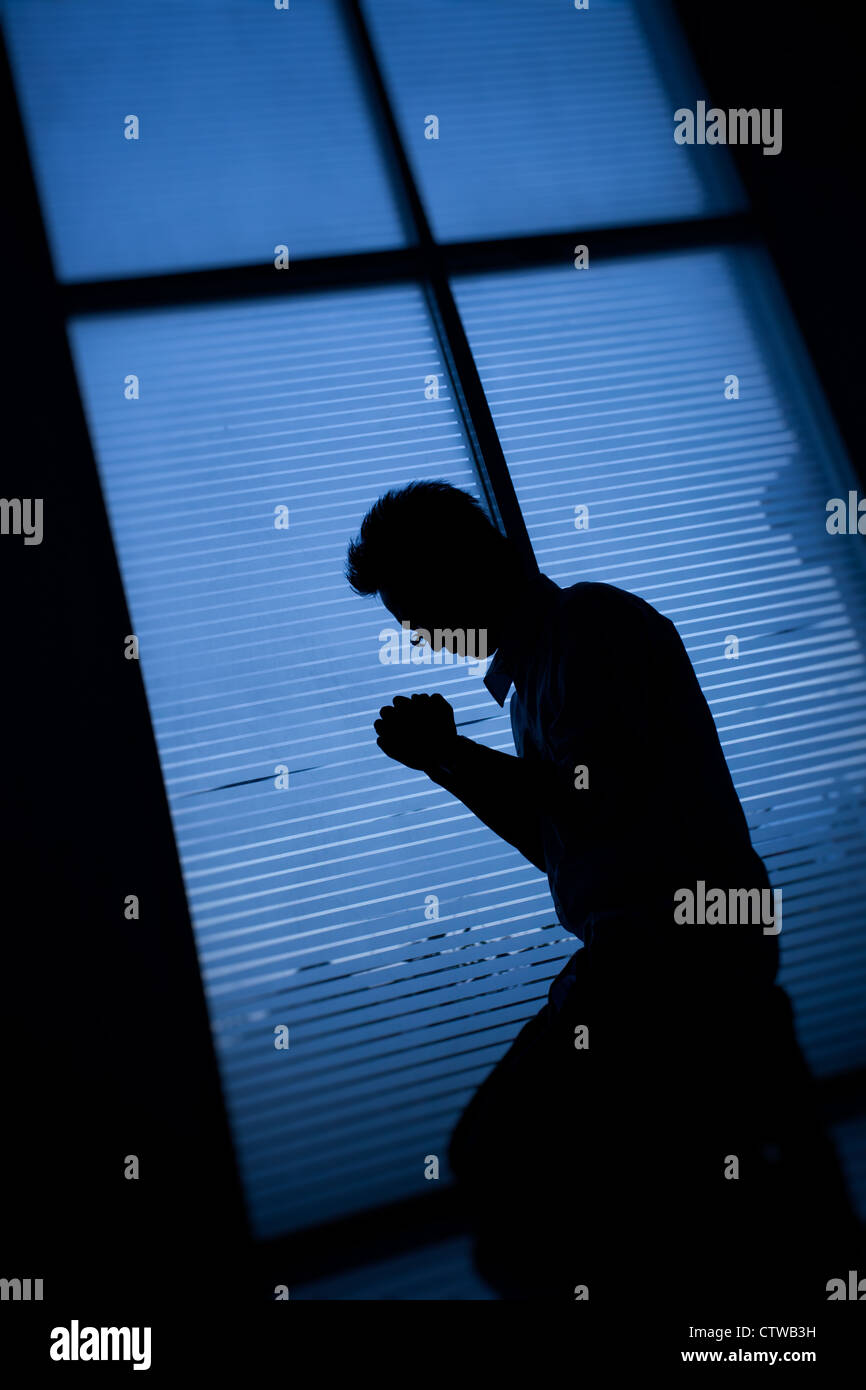 Man kneeling and praying. Stock Photo