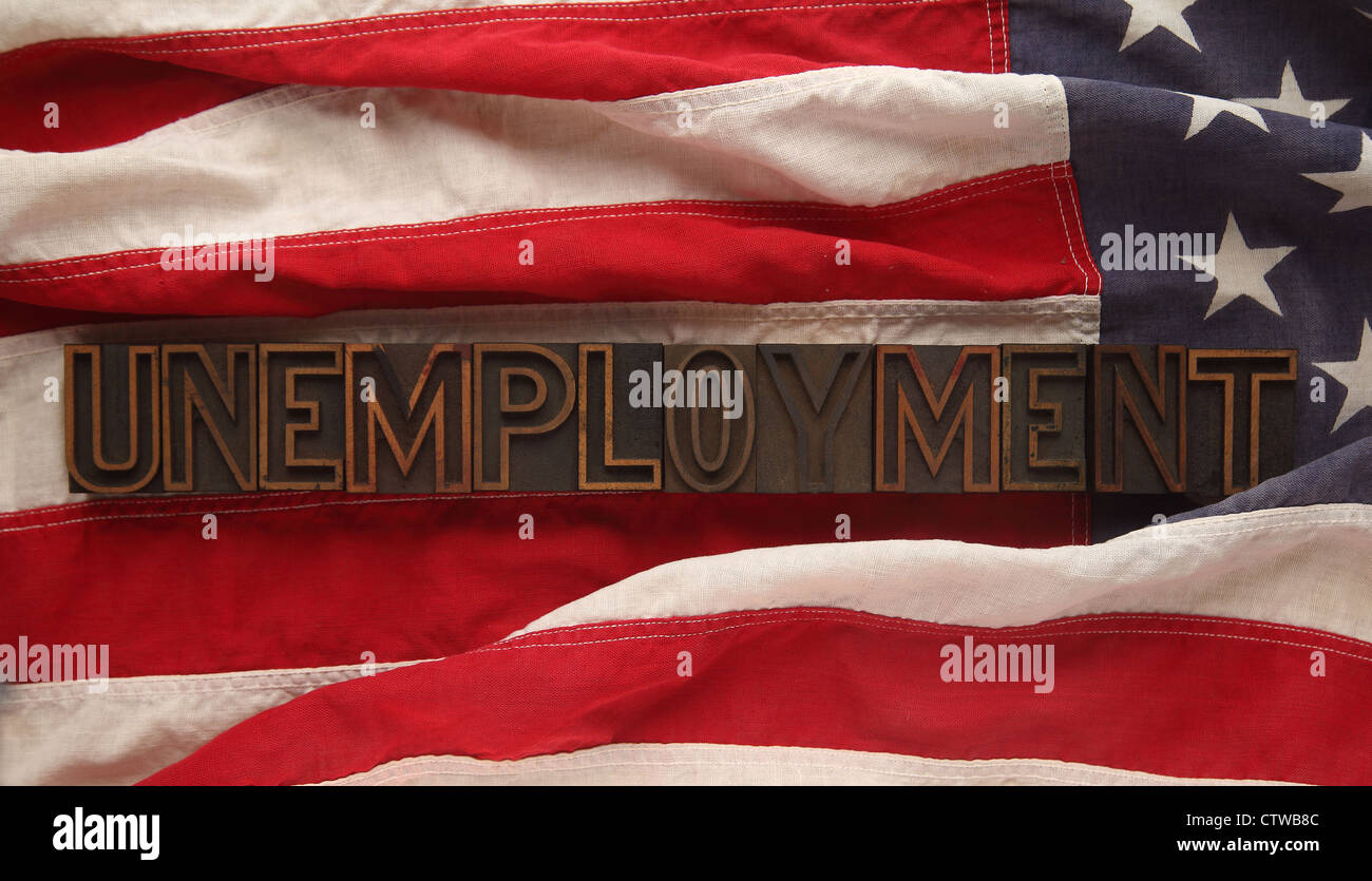 the word unemployment in old wood type on a USA flag Stock Photo