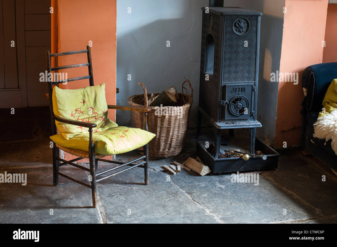 Woodburning stove and a basket of logs in the front room of an english cottage. UK Stock Photo