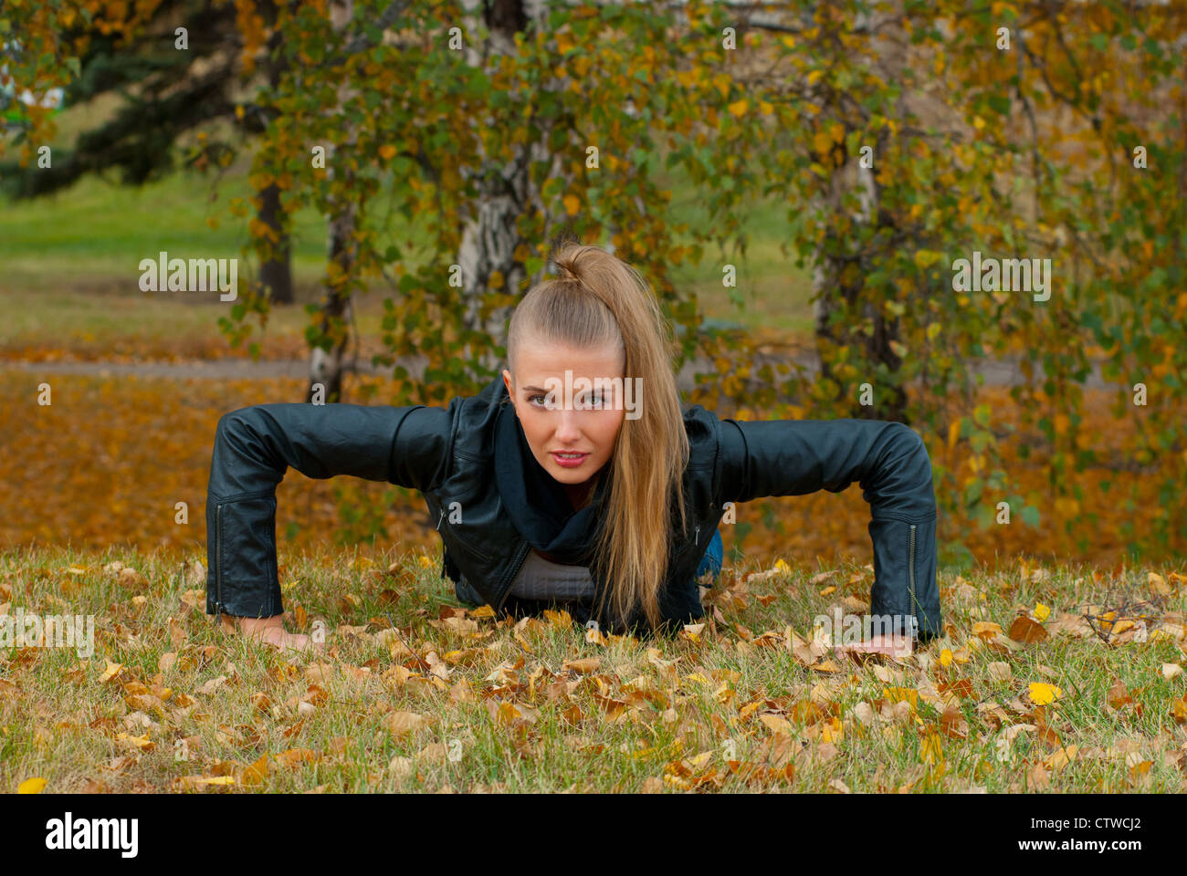 Beauty female doing push ups in the park Stock Photo - Alamy