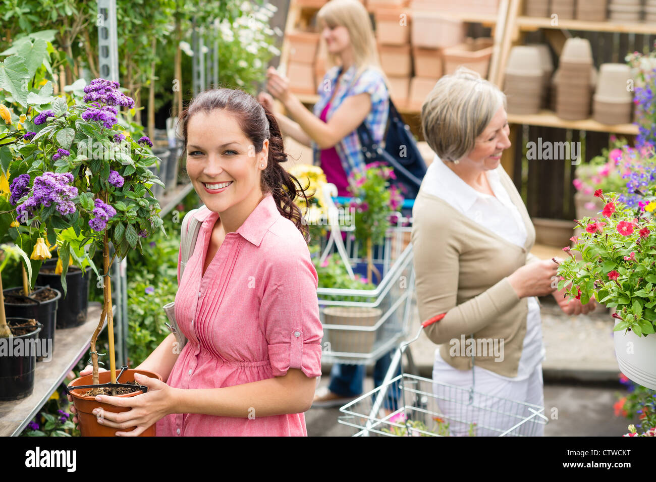 Young woman holding plants garden centre hi-res stock photography and ...