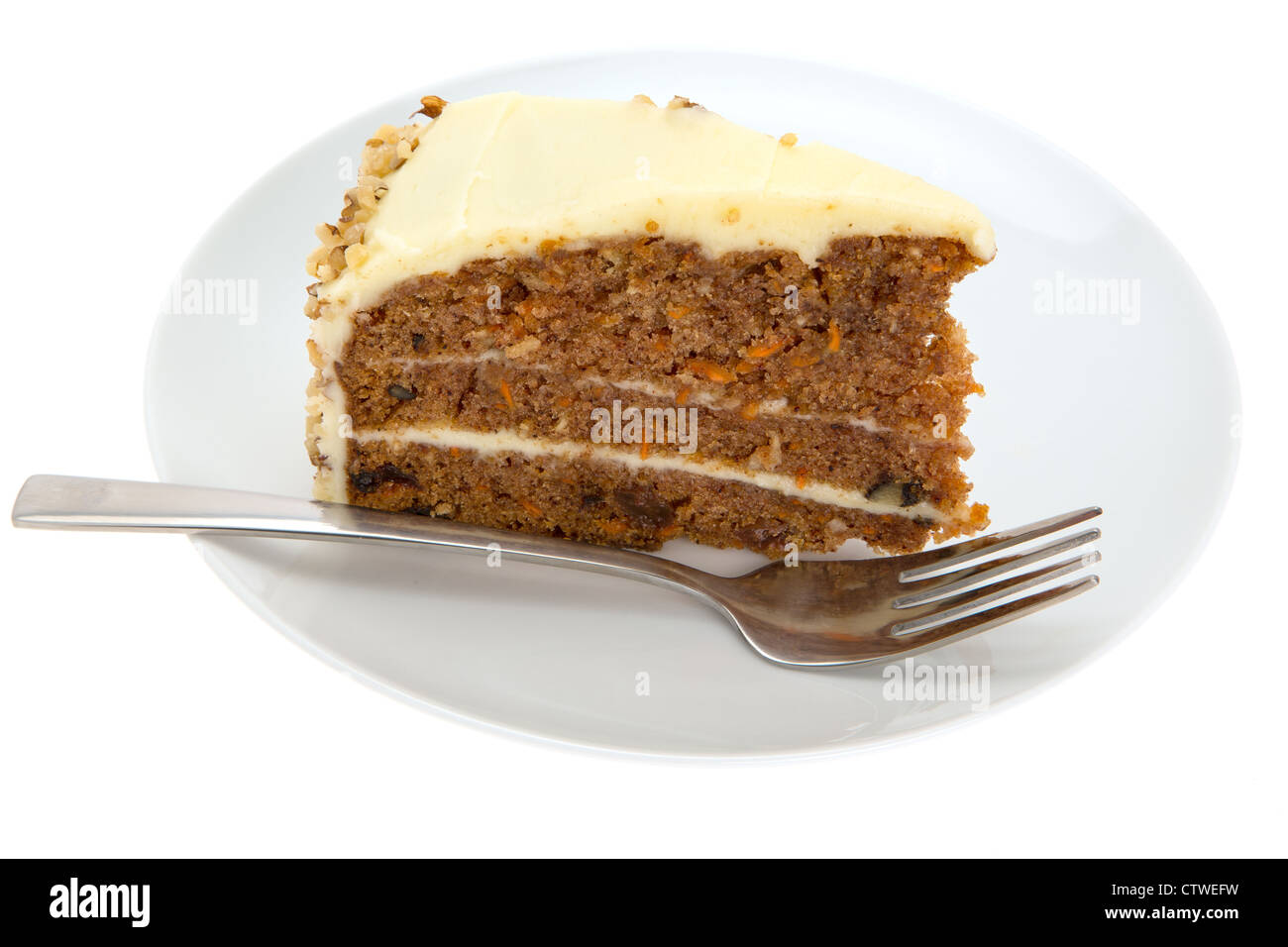 Slice of Carrot Cake on a white plate with a table fork - brightly lit with a shallow depth of field Stock Photo