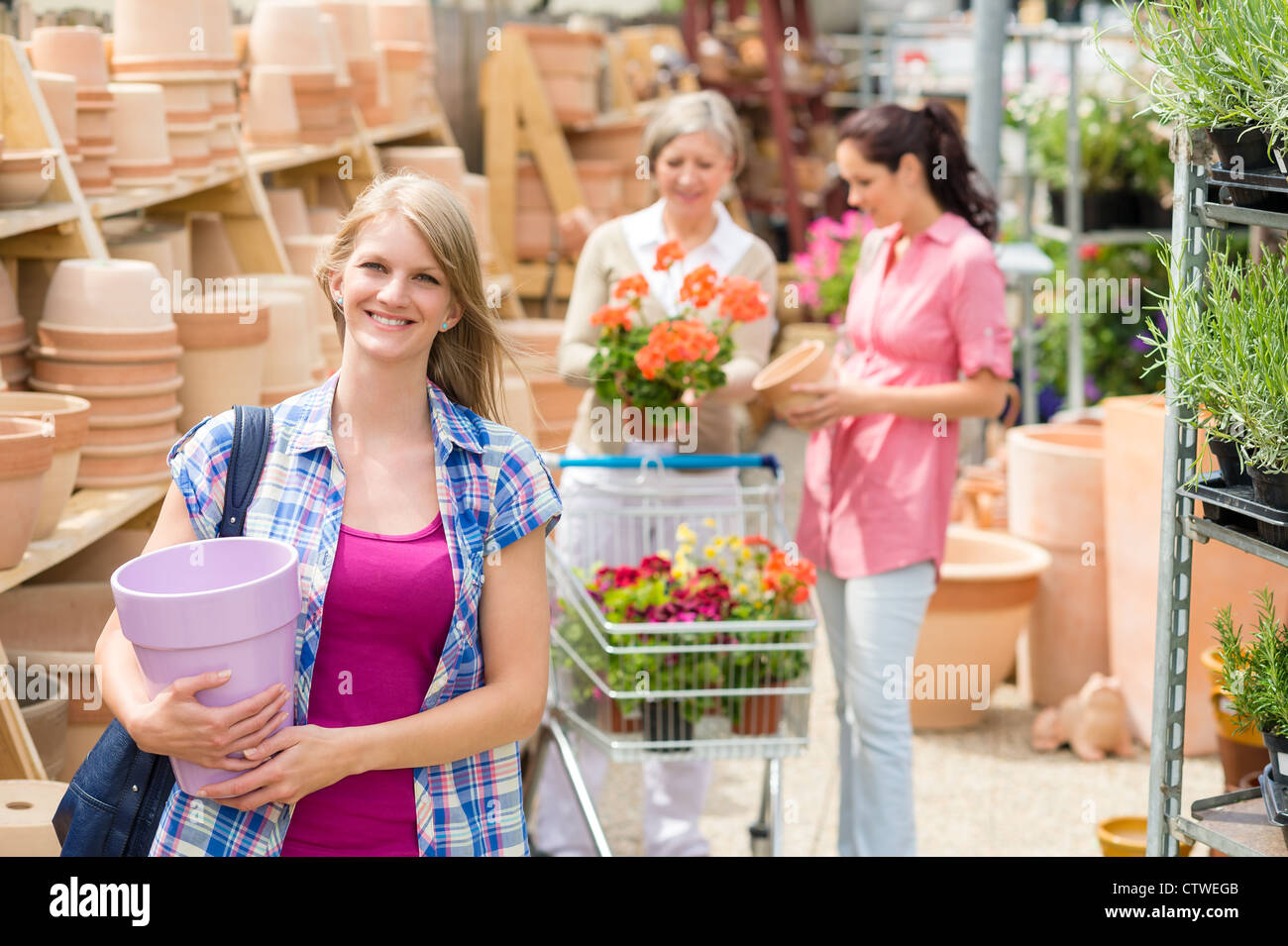 Young woman holding plants garden centre hi-res stock photography and ...
