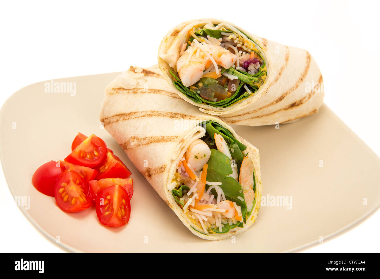 Lime and coriander prawn wrap sandwich with shredded cocunut and fresh lemongrass served on a plate - studio shot Stock Photo