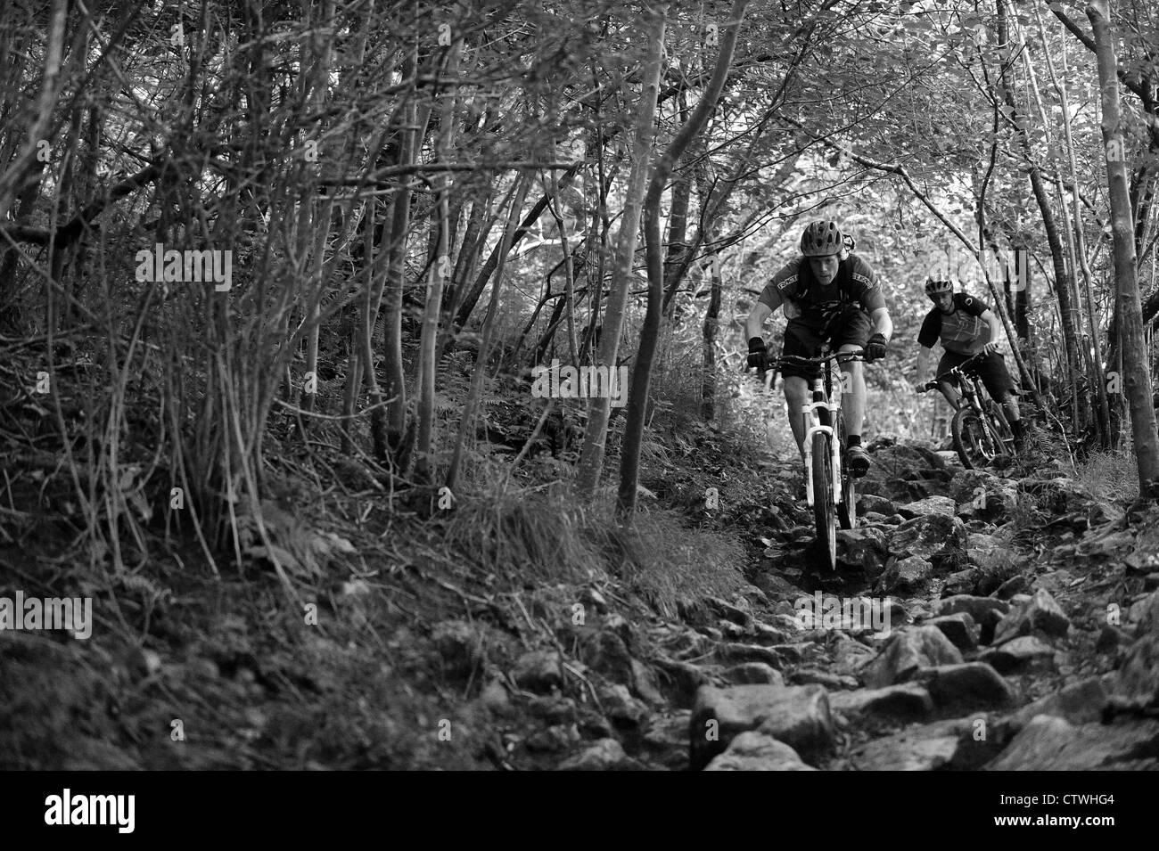Two mountain bikers ride a rocky path near the  village of Cheddar in Somerset on the southern edge of the Mendip Hills. Stock Photo