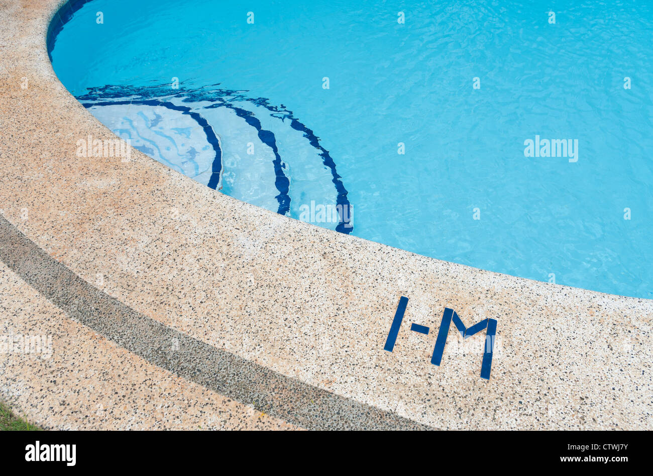 edge of swimming pool with one meter water depth sign Stock Photo