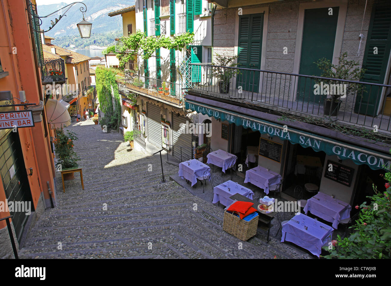 The narrow picturesque street of Salita Serbelloni Bellagio Lake Como Italy with an Italian restaurant and outdoor tables Stock Photo