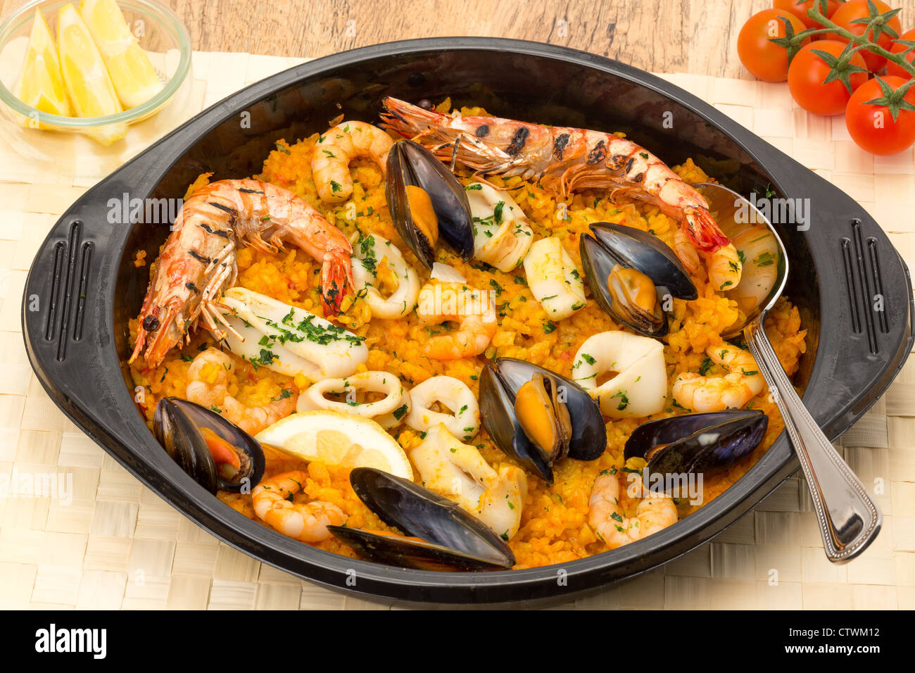 Seafood paella in a black paella serving dish Stock Photo Alamy