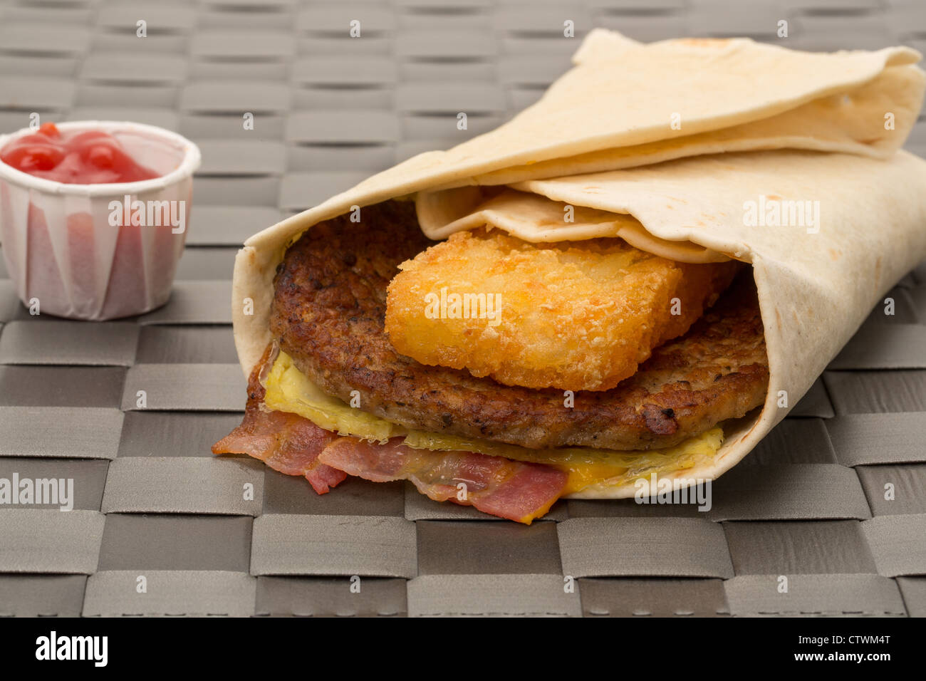 Burger wrap sandwich with bacon and a hash brown - shallow depth of field - studio shot Stock Photo
