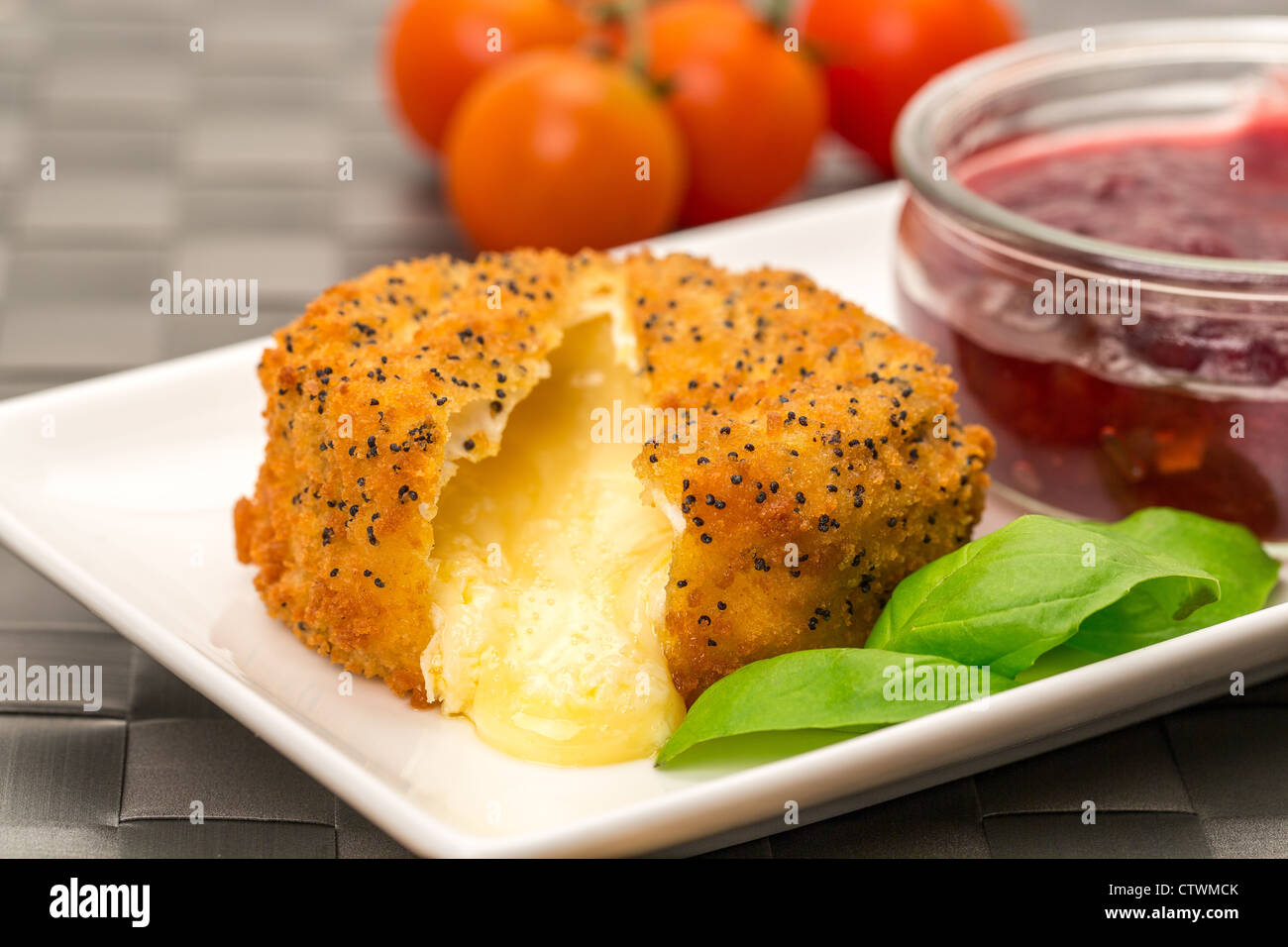 A handmade Camembert cheese covered with poppy seeds and breadcrumbs