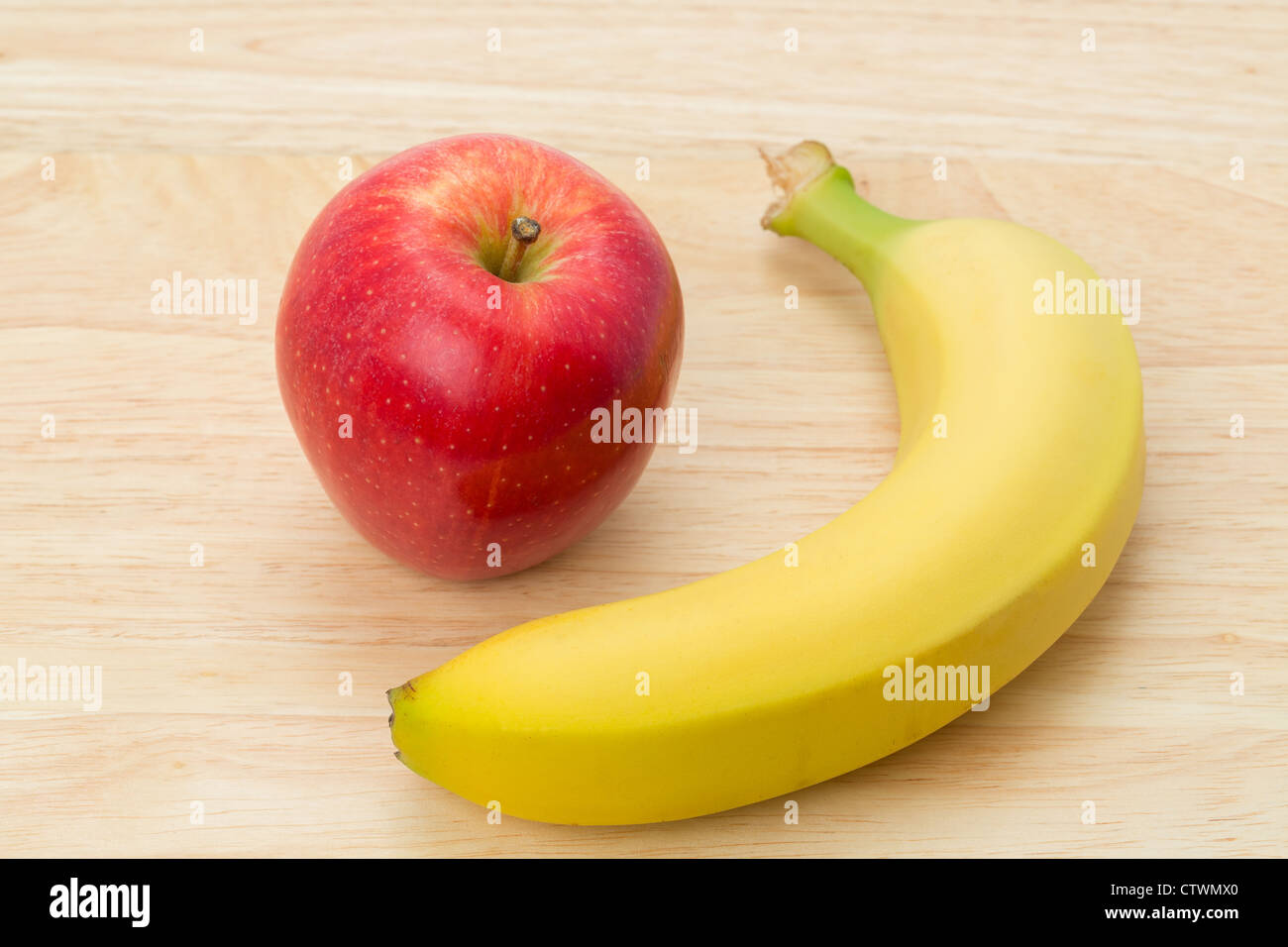 An apple and a banana placed on a table - studio shot Stock Photo