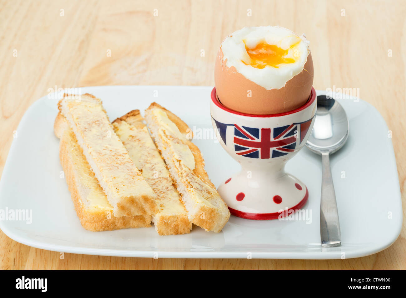 A fresh soft boiled egg in a British egg cup with toasted bread soldier