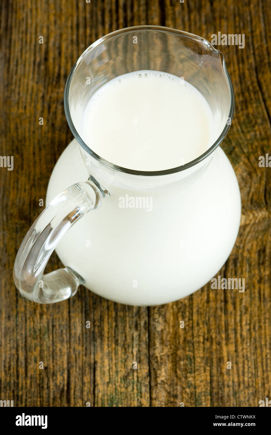 Jug of milk on old wooden table Stock Photo