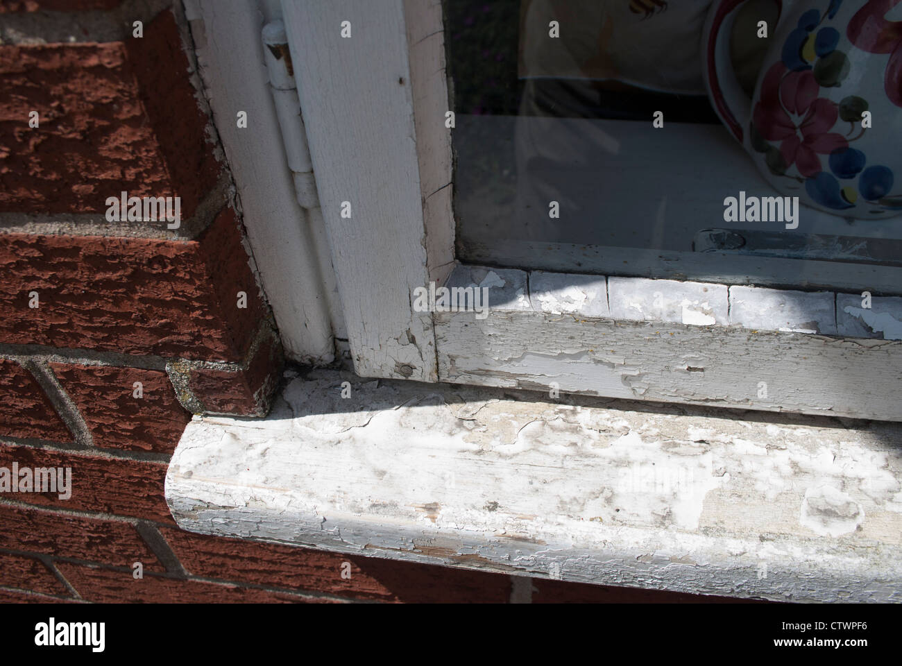 Close up of old chipped and discolored white paint on window and windowsill Stock Photo