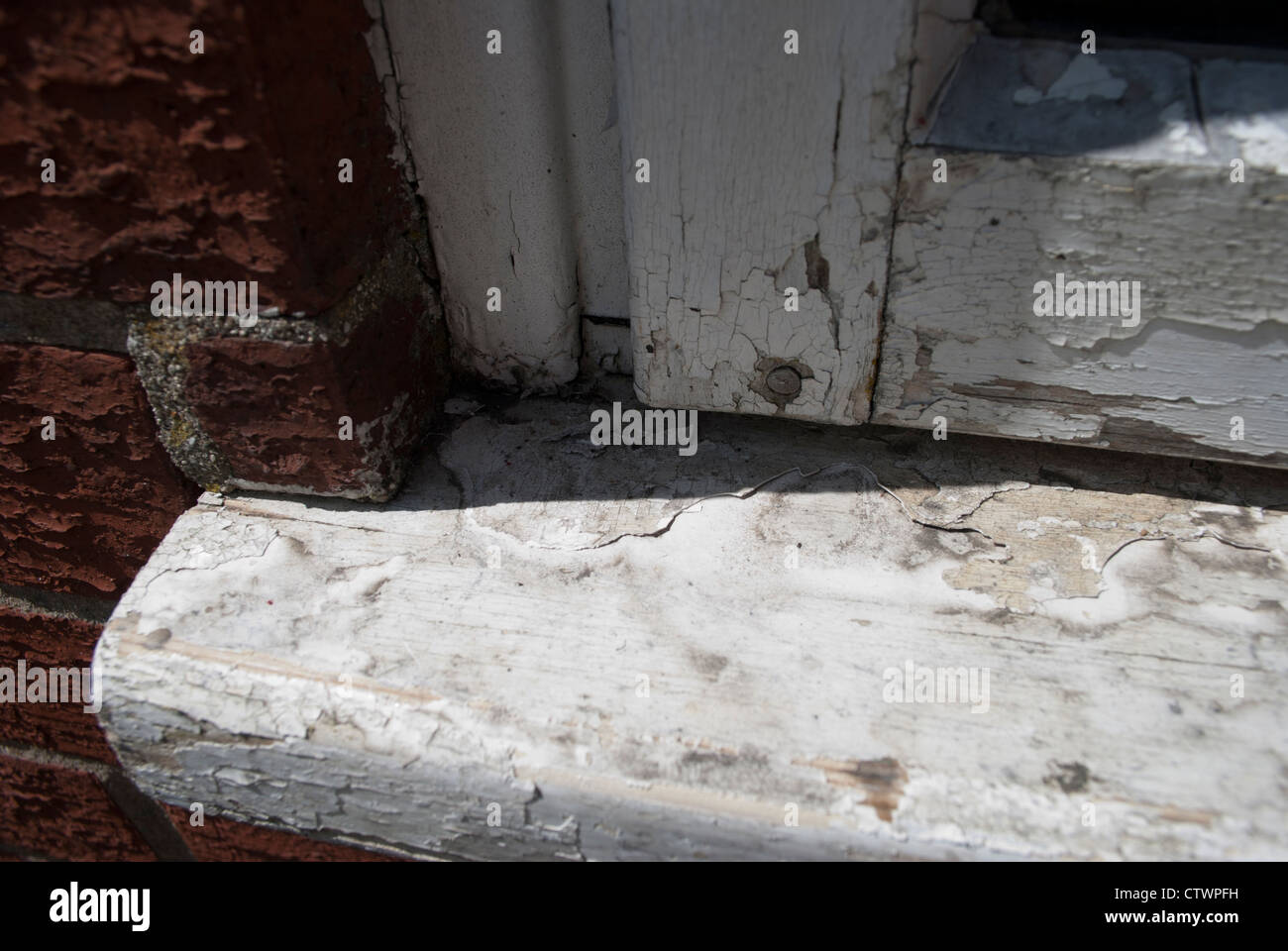 Close up of old chipped and discolored white paint on window and windowsill Stock Photo