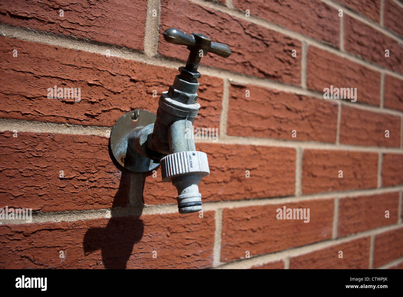 Water tap mounted in red brick wall Stock Photo Alamy