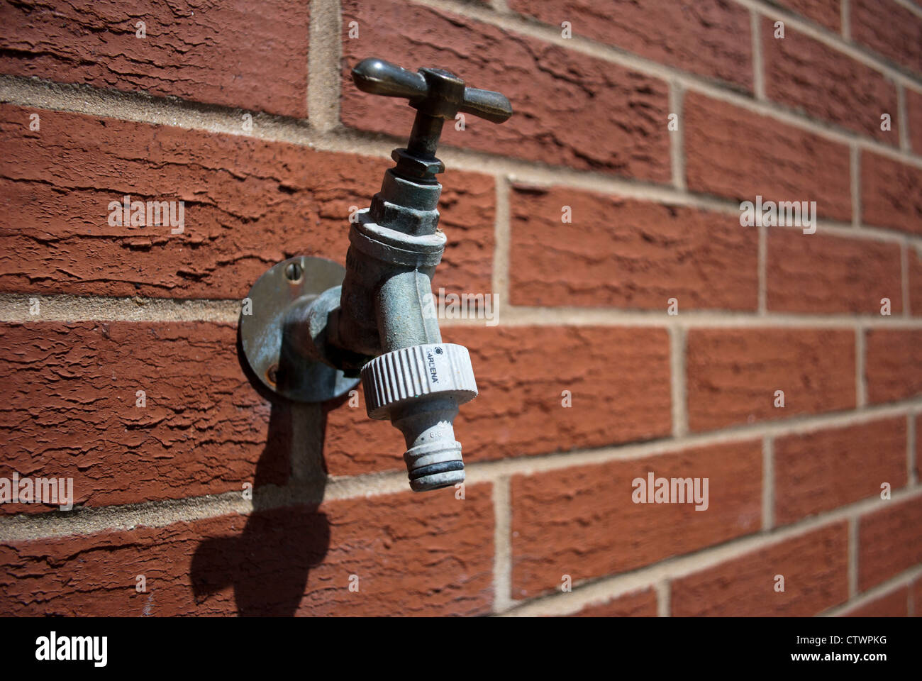 Water tap mounted in red brick wall Stock Photo - Alamy