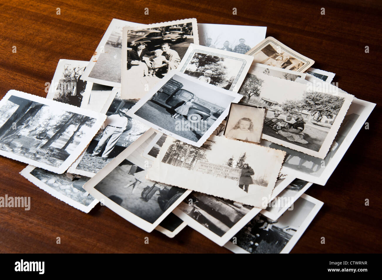 Pile of old black and white family photographs on a table Stock Photo