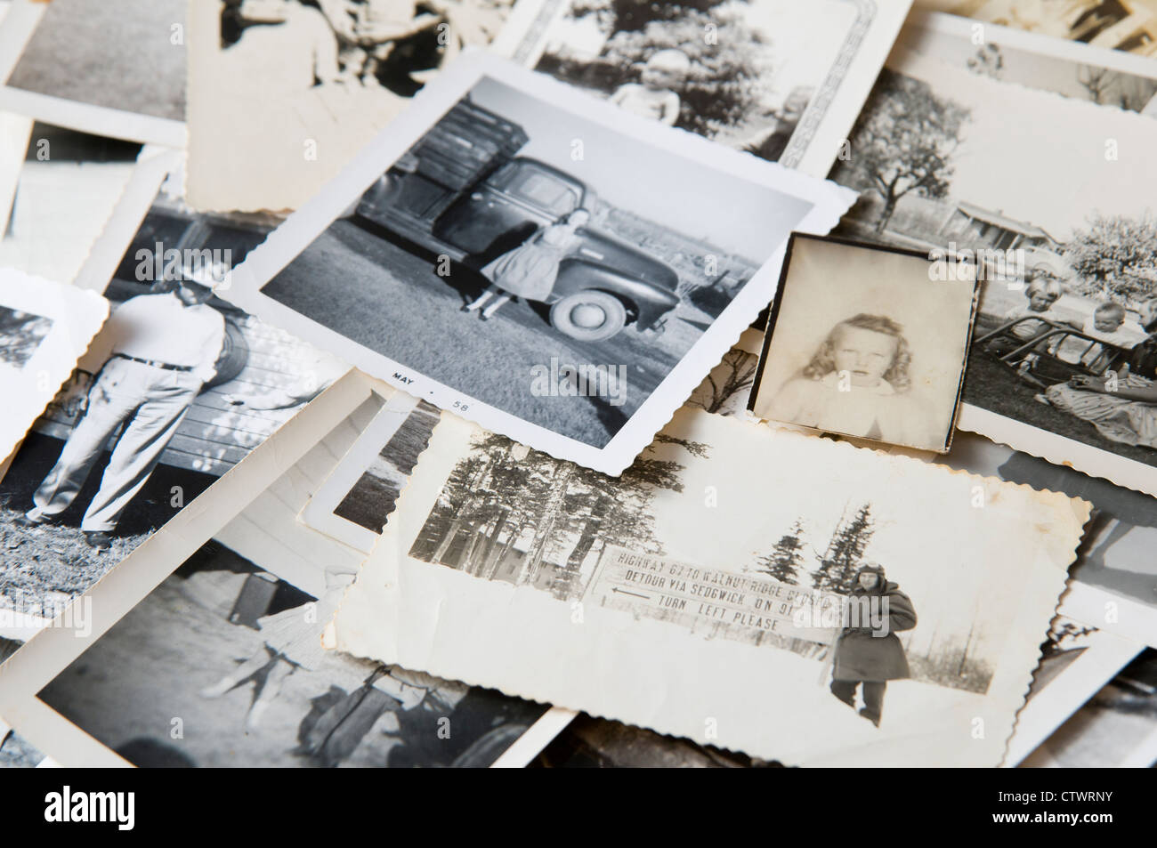 Pile of old black and white family photographs on a table Stock Photo