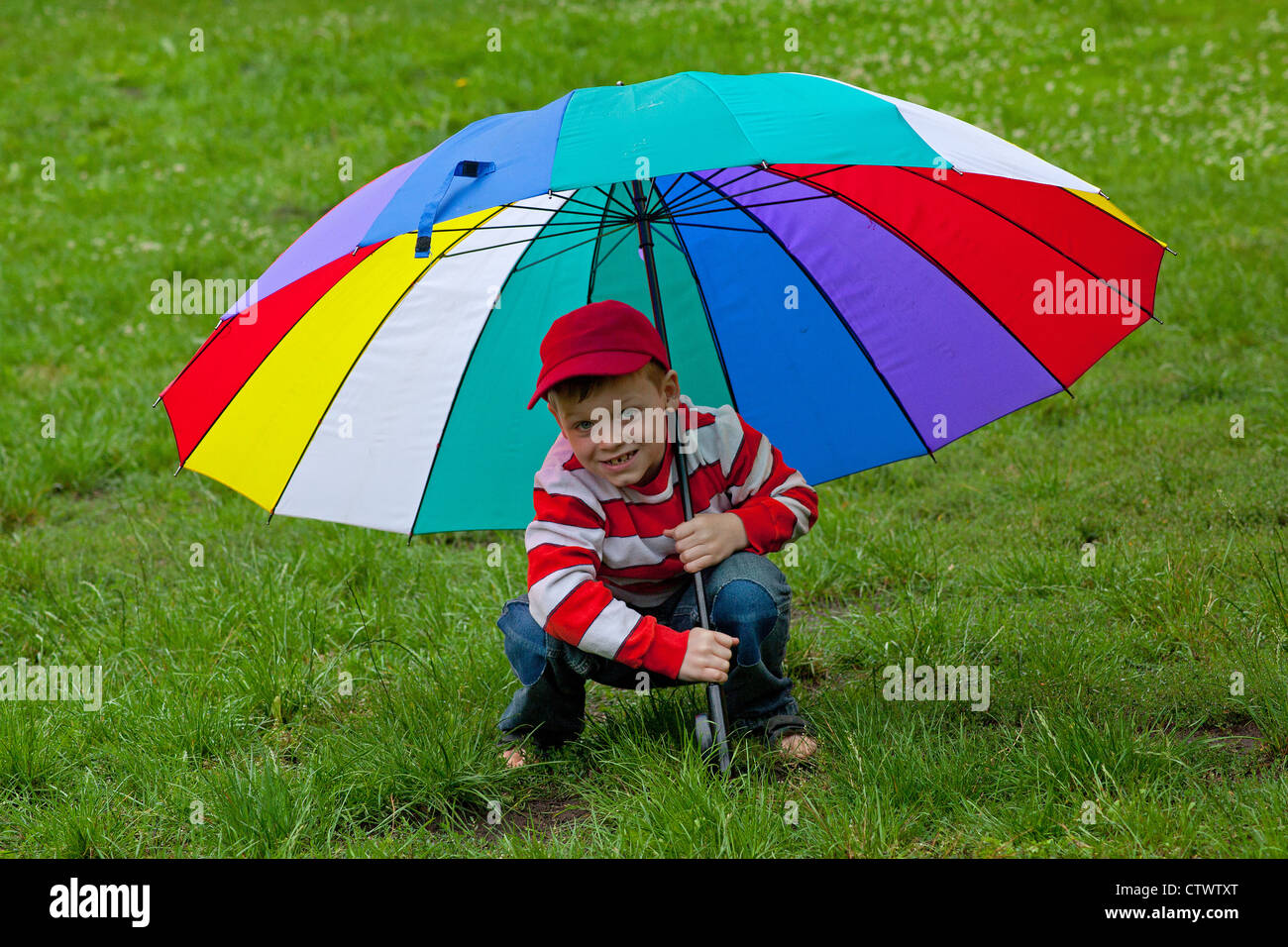 young boy with a big colourful umbrella Stock Photo