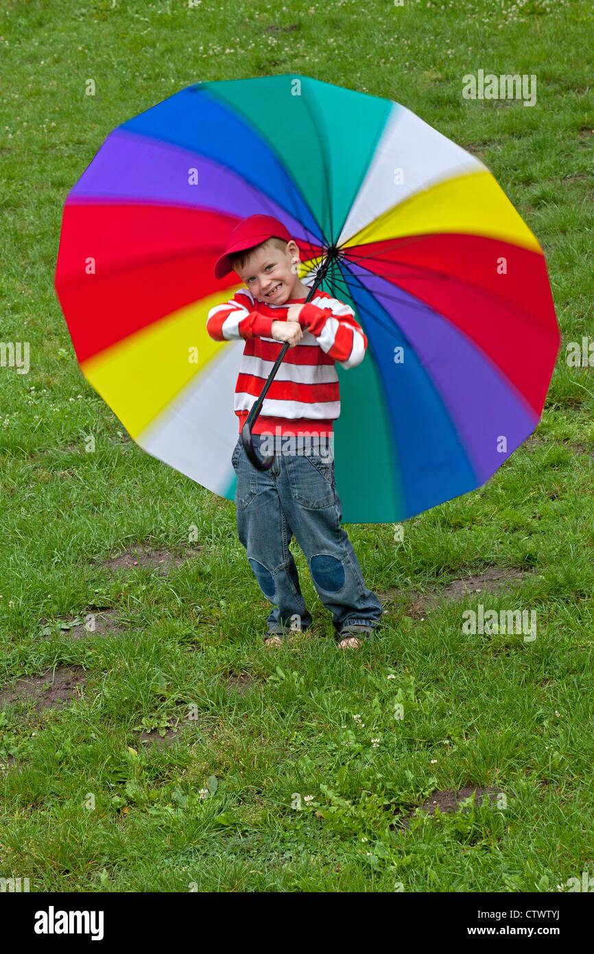 young boy with a big colourful umbrella Stock Photo