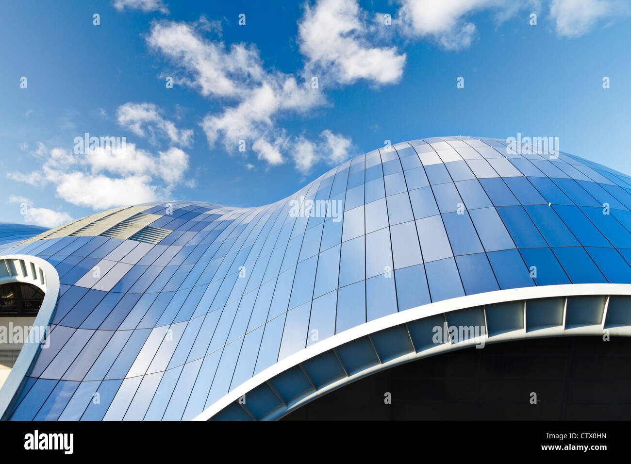 The glass roof of the Sage concert hall reflecting clouds in a blue sky, Gateshead, Tyne and Wear, England Stock Photo
