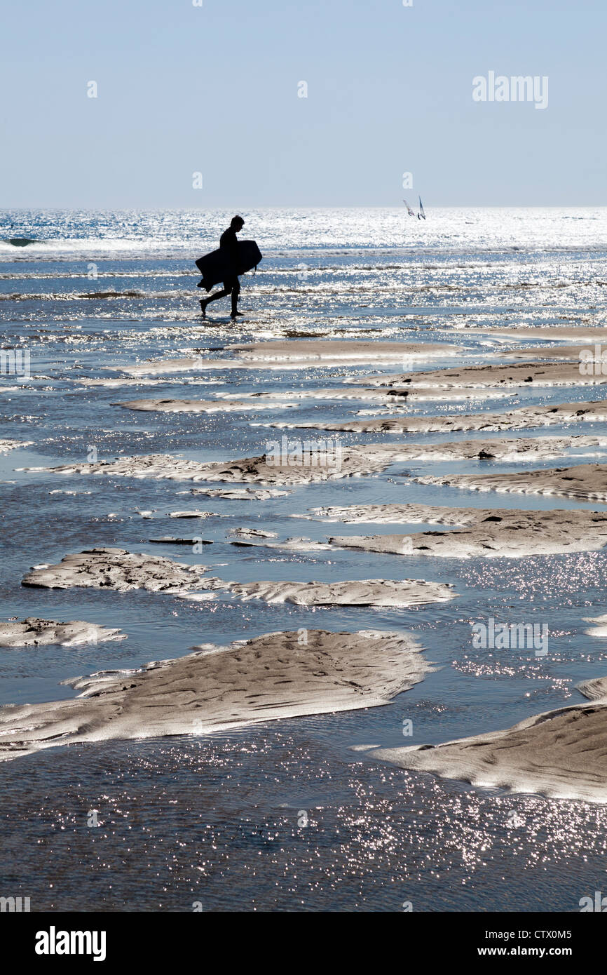 Body boarder silhouetted against the incoming tide at Bantham, Devon Stock Photo