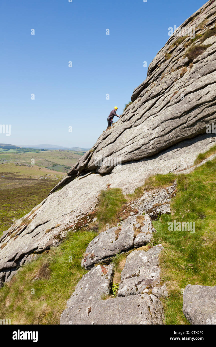 Man climbing on Haytor Rocks, a granite tor on Dartmoor, Devon, UK Stock Photo