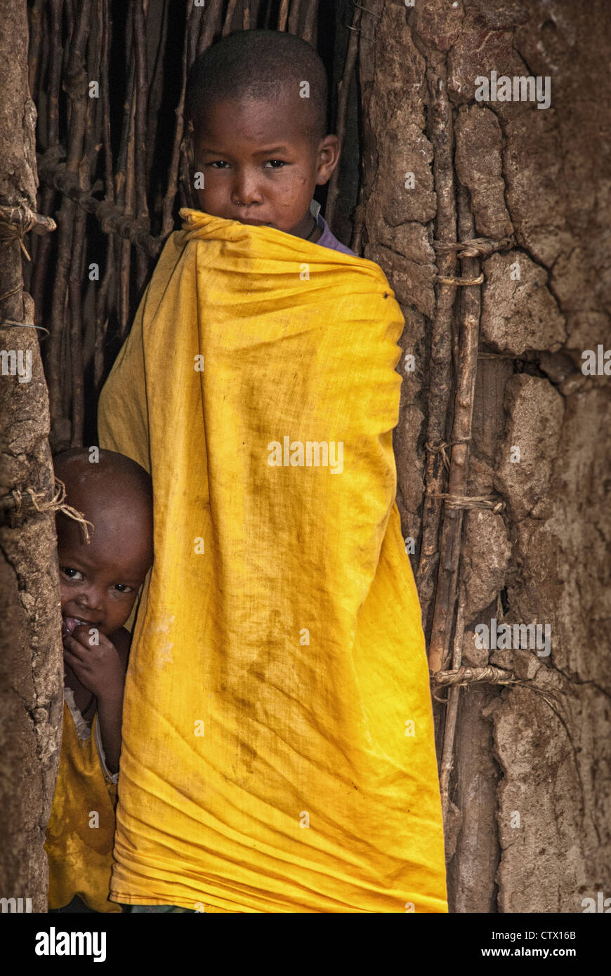 Masai Child in the doorway of a mud hut in a village near the Masai Mara, Kenya, East Africa Stock Photo