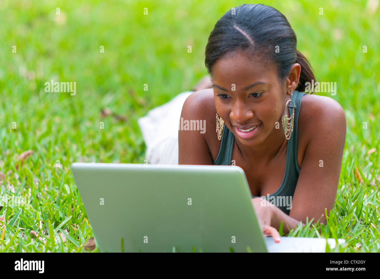 Young African American woman student studying using internet outdoors ...