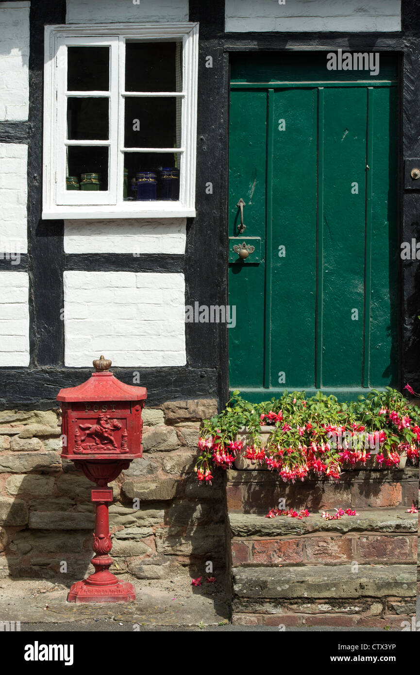Old historic royal mail post box outside a Black and White English Timber framed building. Pembridge. Herefordshire. England Stock Photo