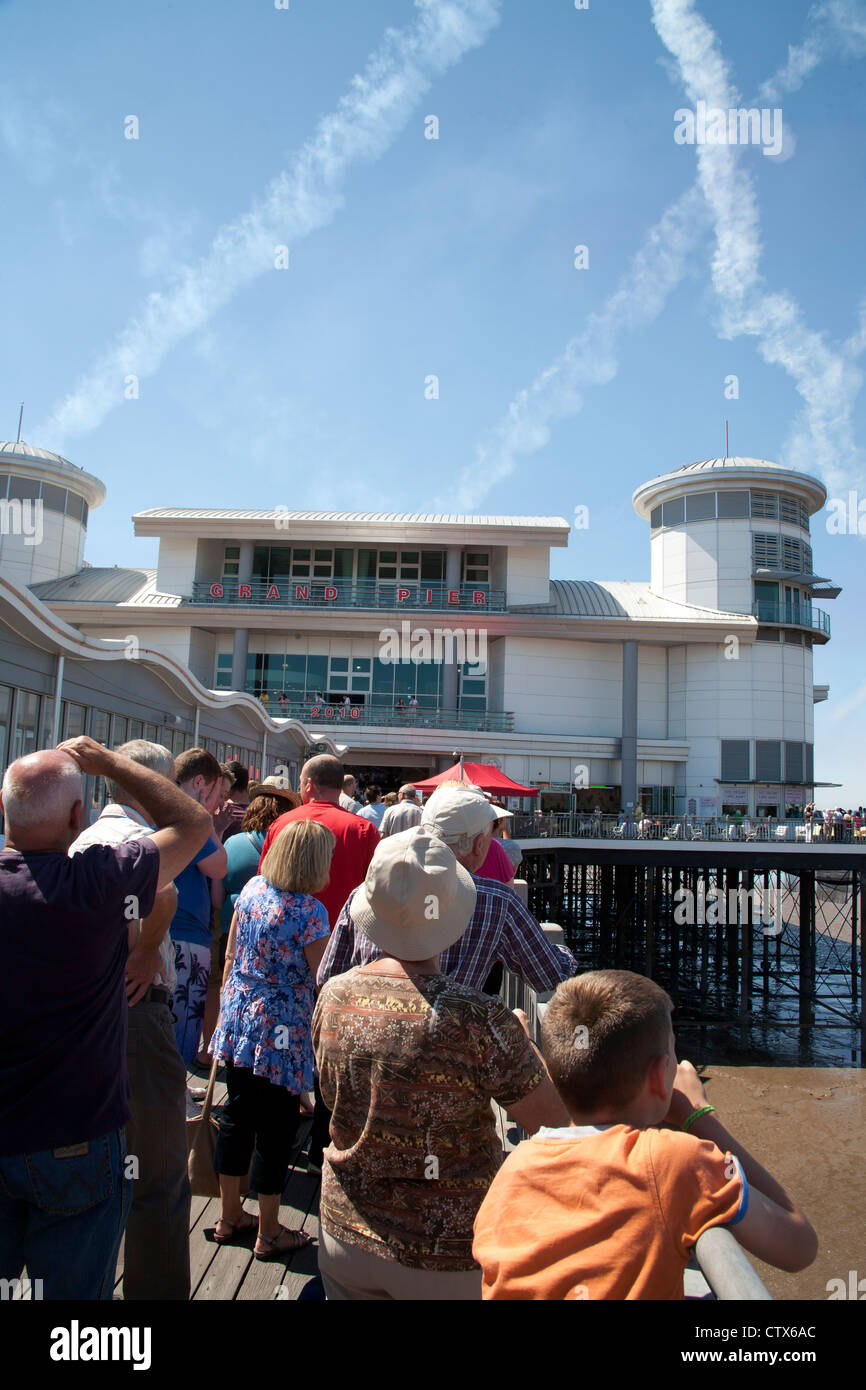 People watching the Red Arrows flying over the pier as part of the Grand Pier Air Show Weston Super Mare Somerset UK Stock Photo