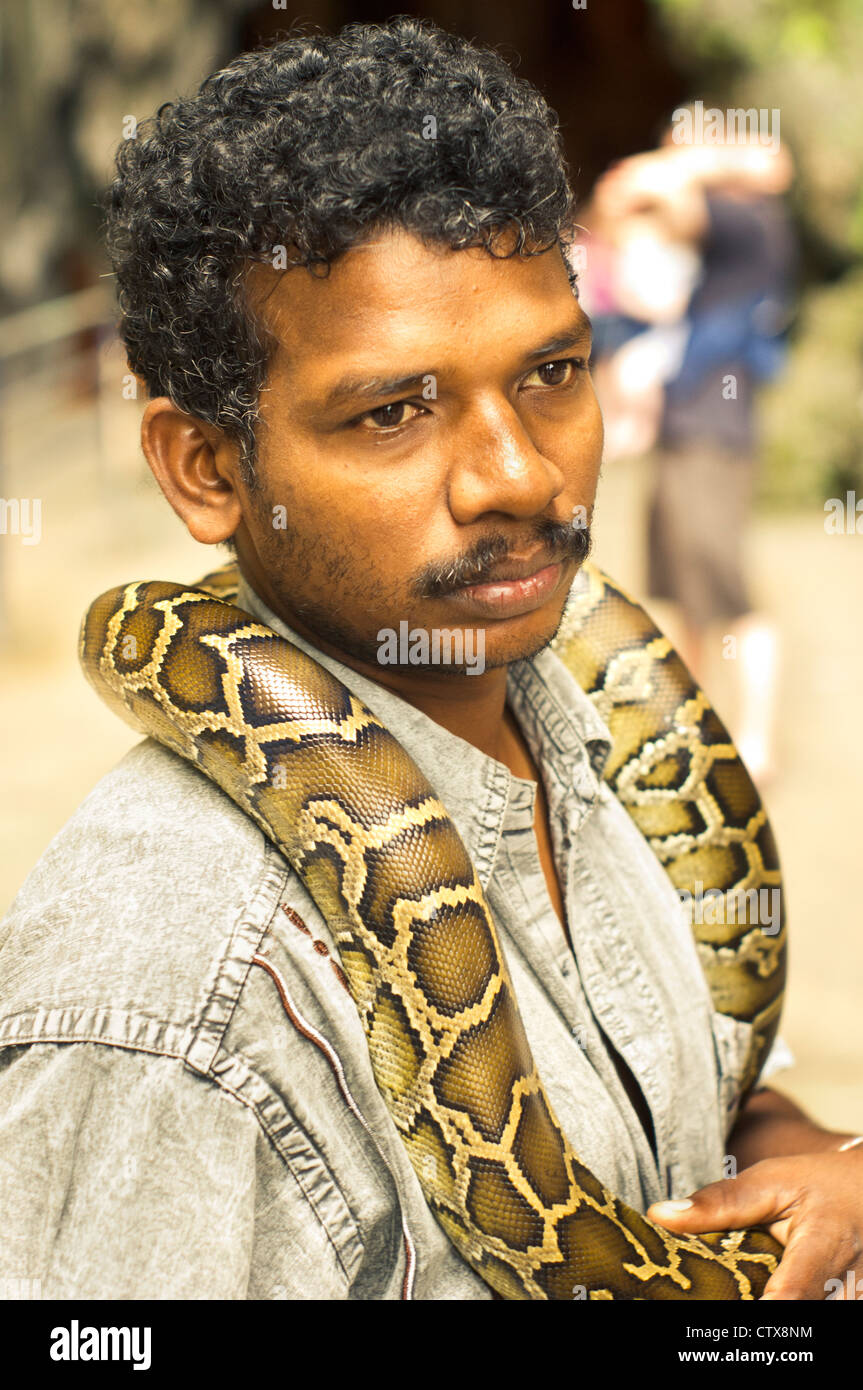 an indian snake charmer is busking with snake in batu cave of kuala lumpur, malaysia. Stock Photo