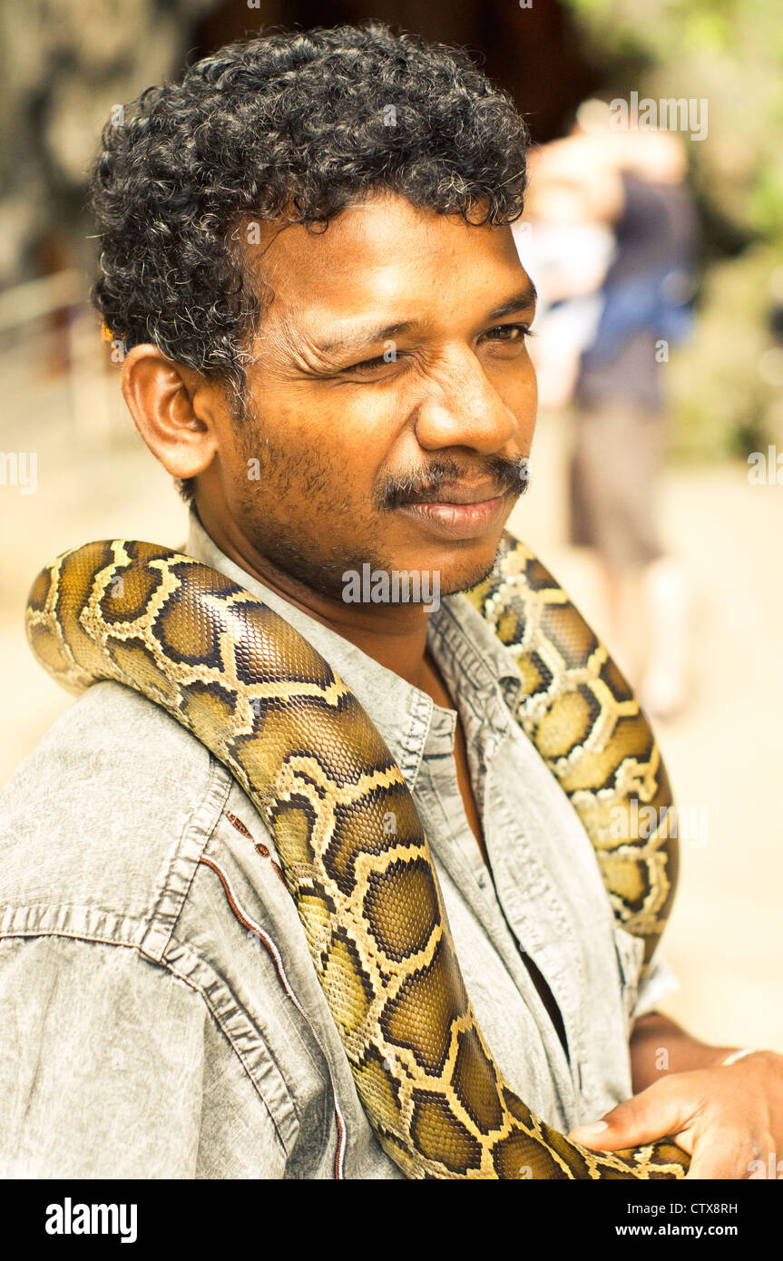 an indian snake charmer is busking with snake in batu cave of kuala lumpur, malaysia. Stock Photo