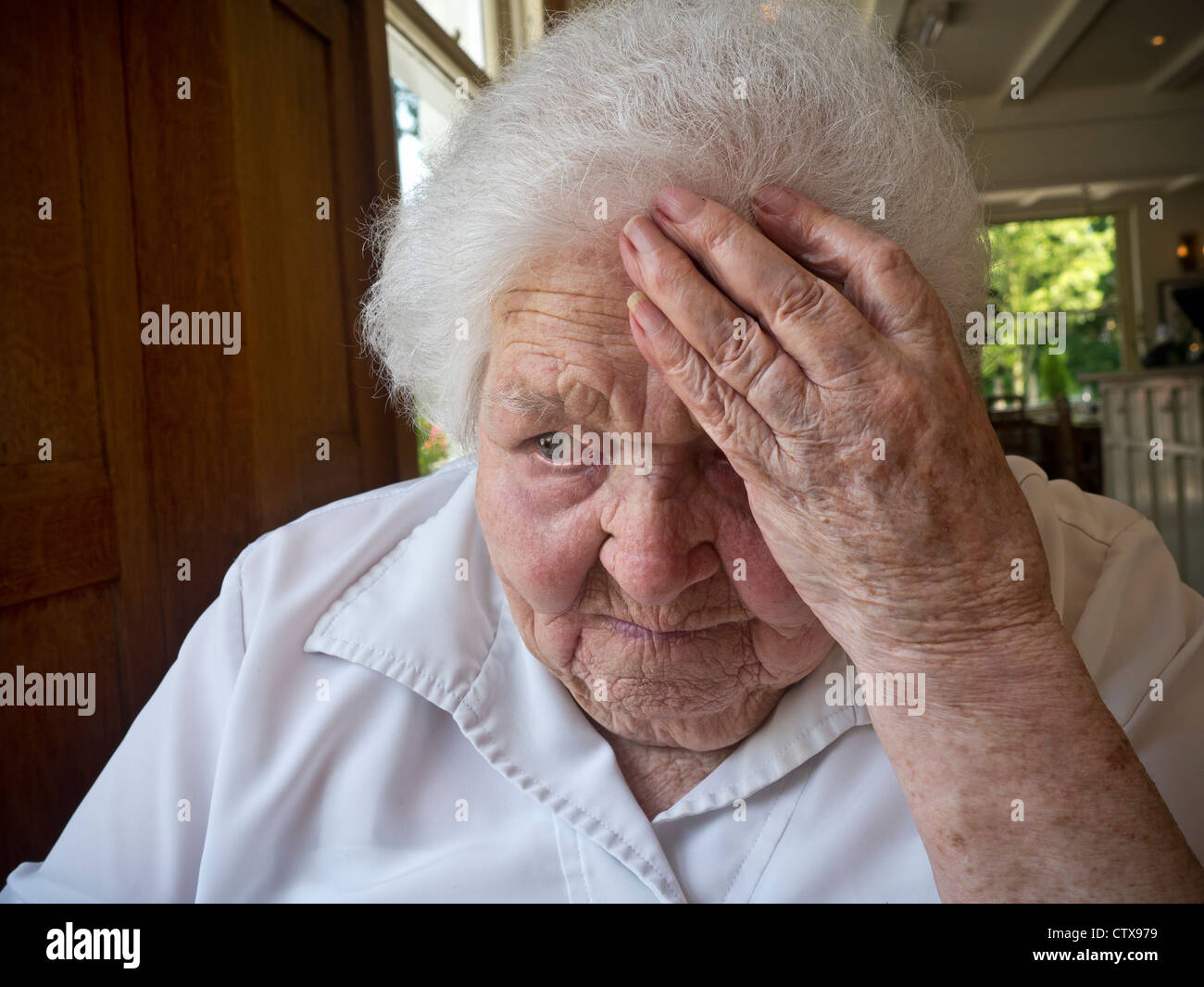 ELDERLY LADY WINTER FUEL ENERGY PRICES HEATING WORRIED CARE HOME SAD  Apprehensive worried vulnerable senior elderly old age lady indoors living room Stock Photo