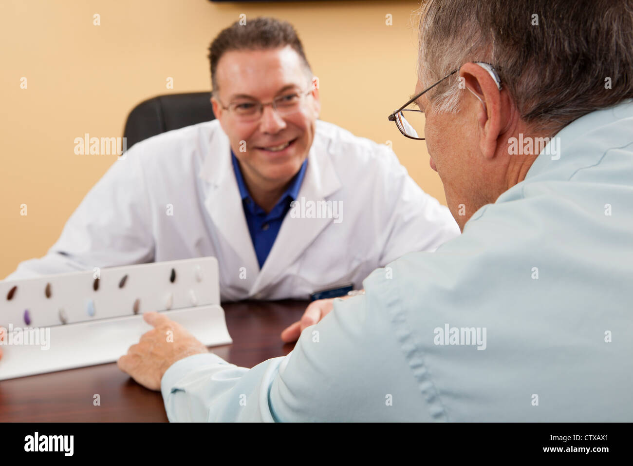 Patient choosing hearing aid color with an audiologist Stock Photo - Alamy