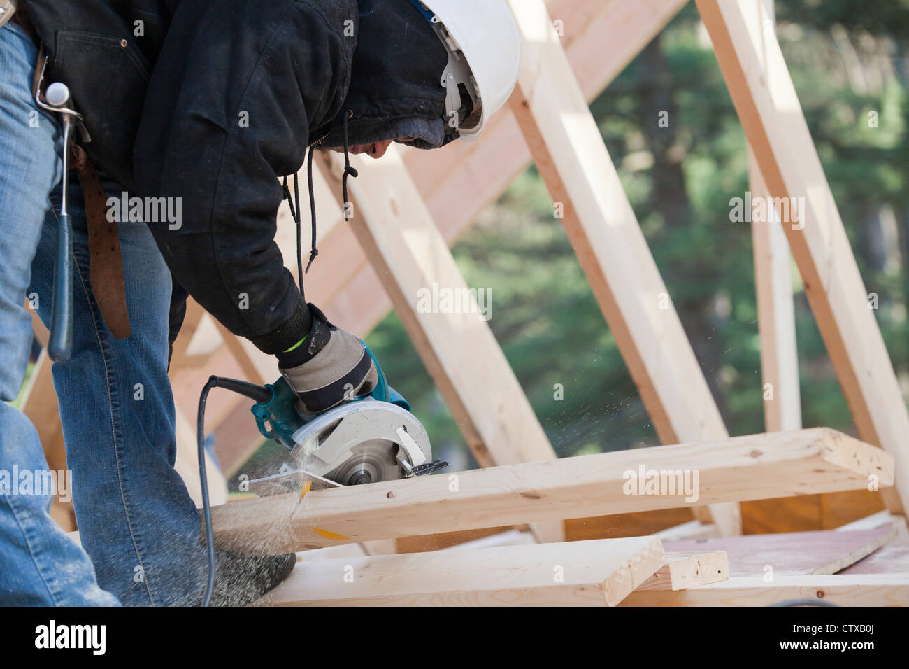 Carpenter using a circular saw making bevel cut Stock Photo