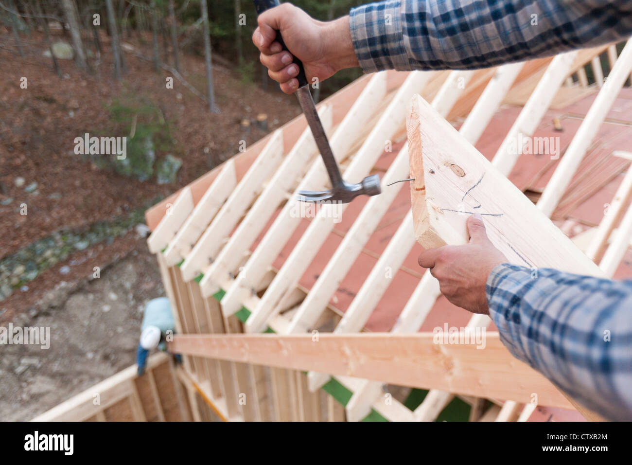 Carpenter removing nail from rafter end Stock Photo