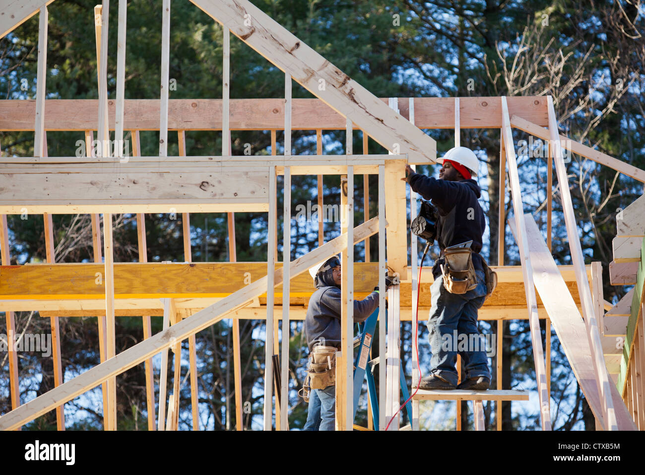 Carpenters Using A Nail Gun On Dormer Framing Stock Photo