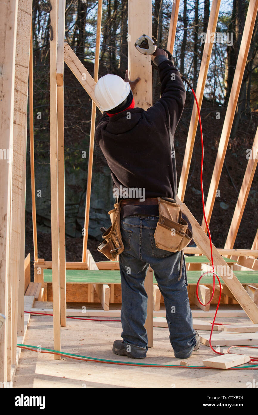 Carpenter nailing a temporary brace in place Stock Photo Alamy