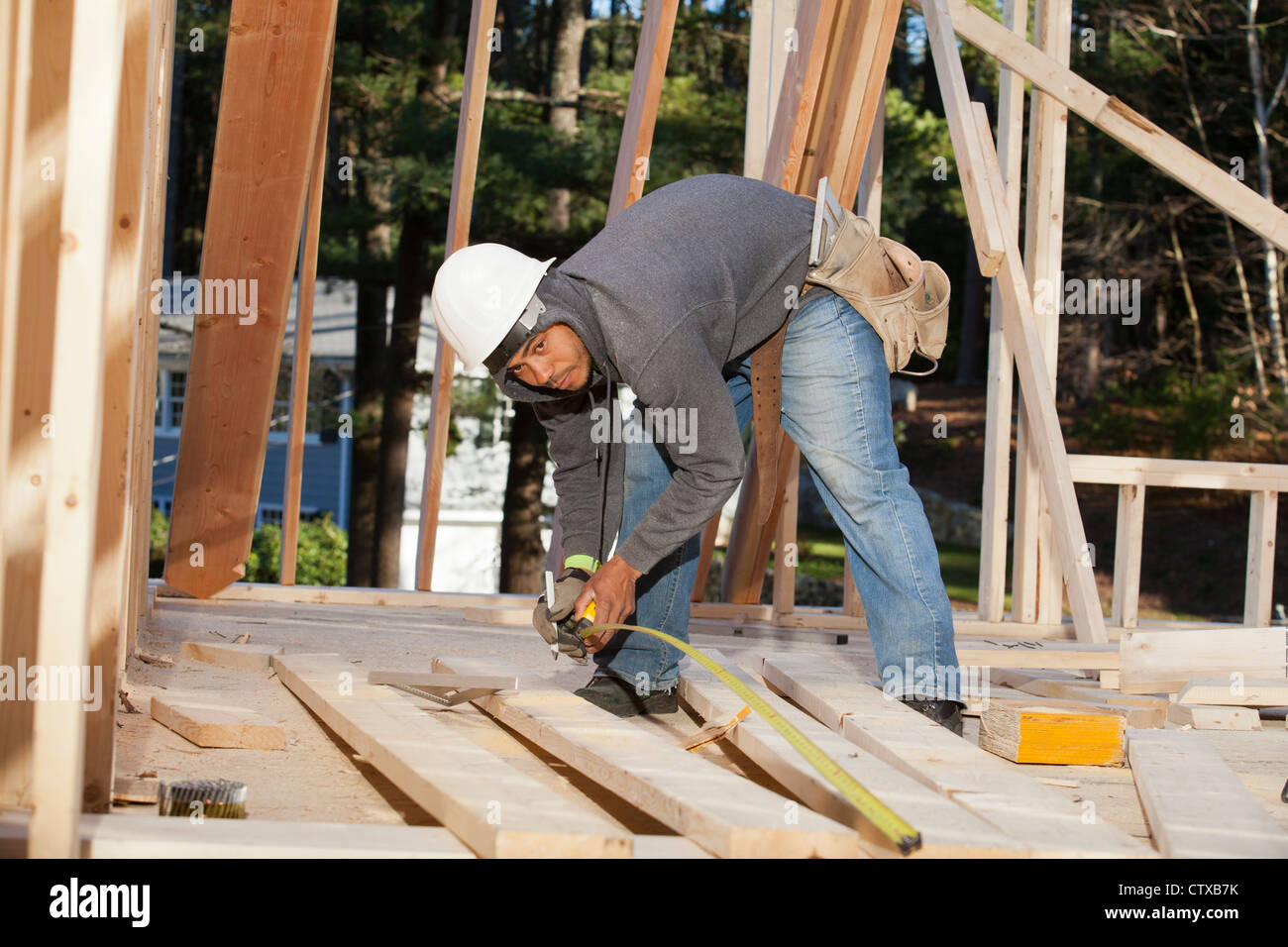 Carpenter measuring board length Stock Photo