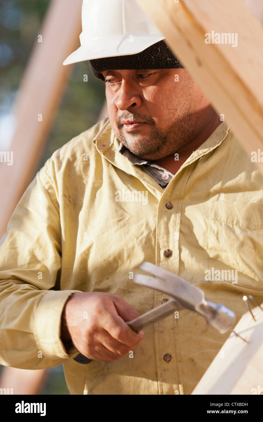 Carpenter removing nails from stud Stock Photo