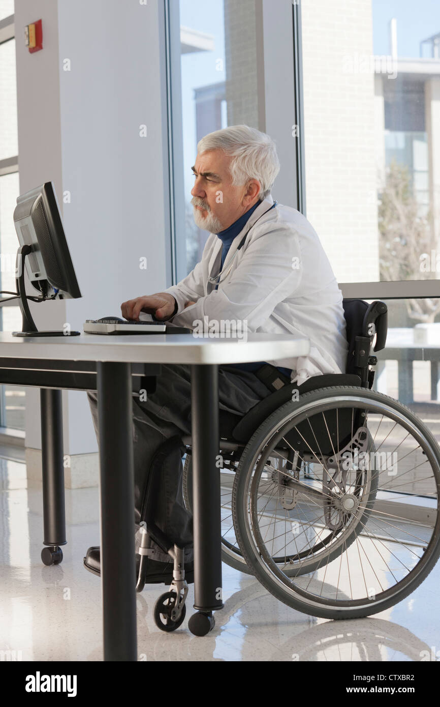 Doctor with muscular dystrophy in wheelchair studying information on