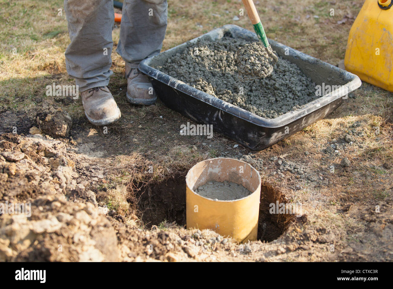 Hispanic carpenter mixing cement for deck footing Stock Photo Alamy