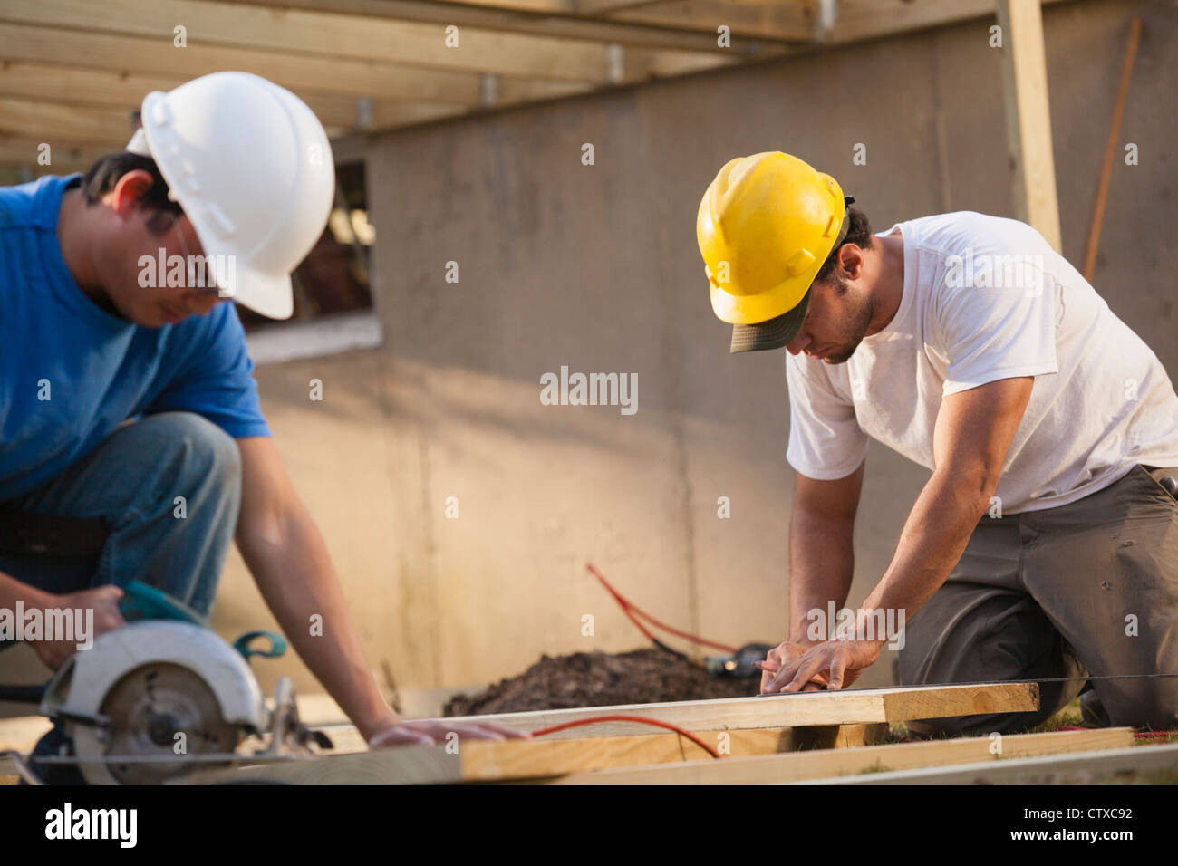 Carpenters measuring and cutting deck joists Stock Photo Alamy