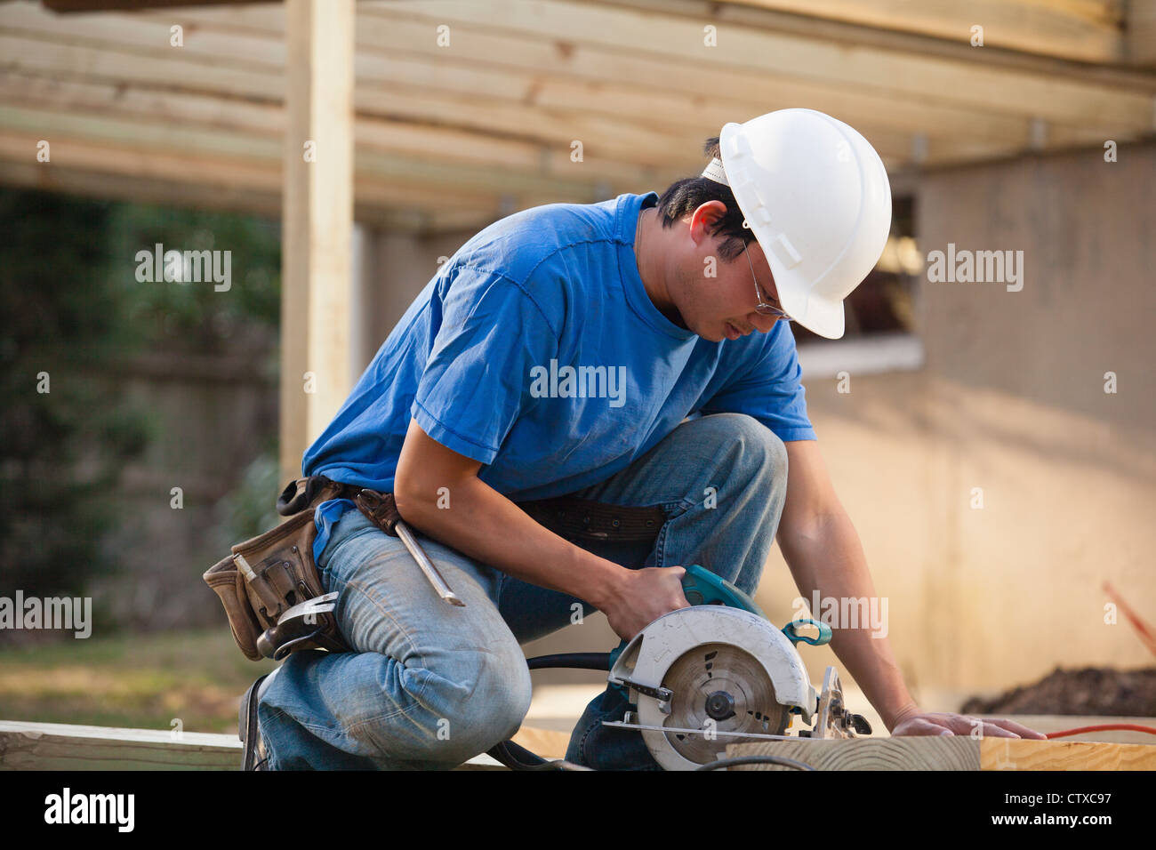 Carpenter cutting deck joist with a circular saw Stock Photo Alamy