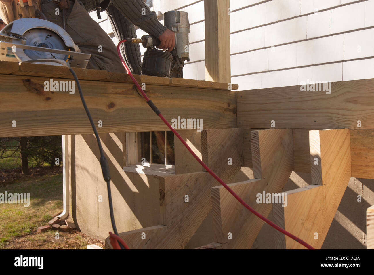 Hispanic carpenter nailing decking at stair stringers Stock Photo Alamy