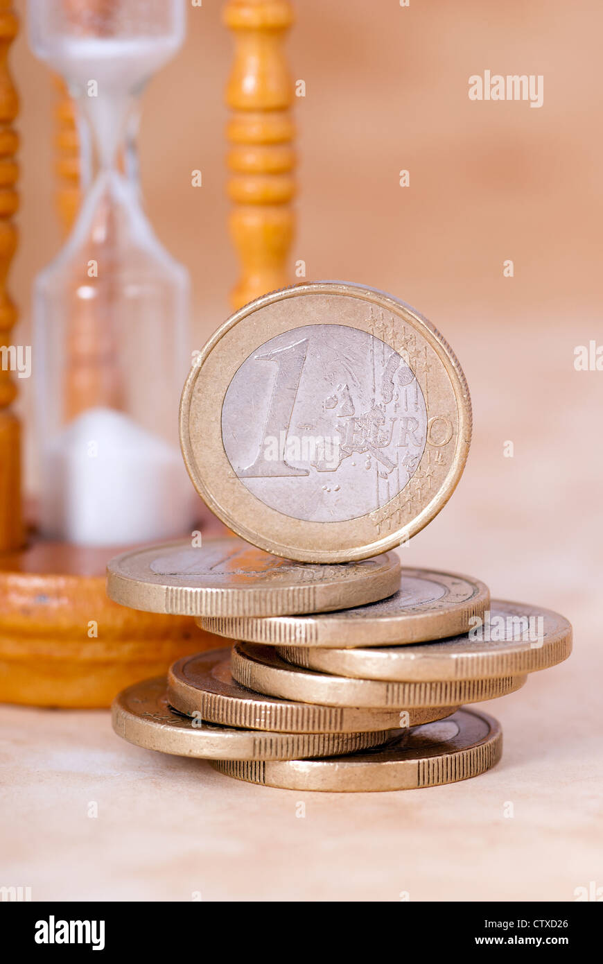 Euro Coins with an Hourglass in the background Stock Photo