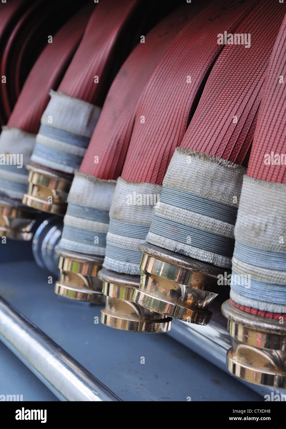 Close up of shiny brass couplings on fire service hose. Stock Photo