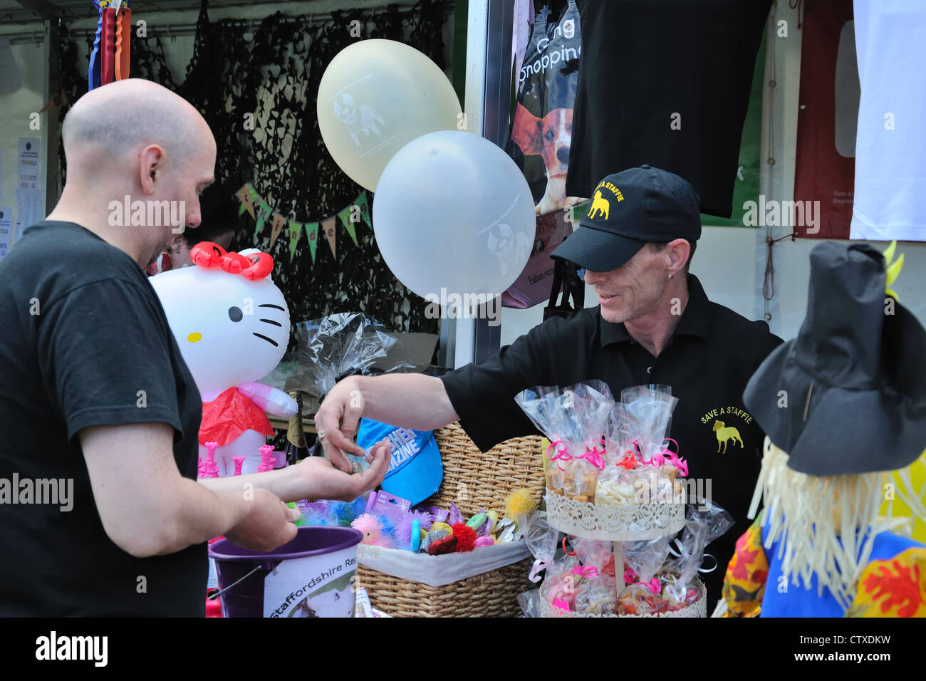 Man receiving money/change from a charity stall at the Pollok park family day in Glasgow, Scotland, UK. Stock Photo